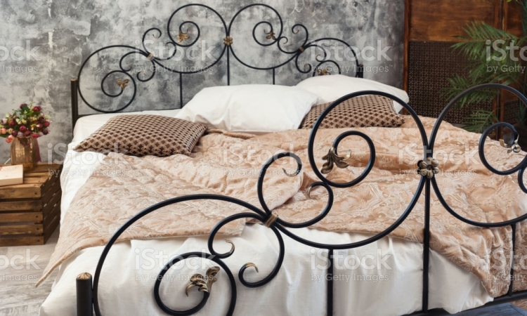 Large double wraought iron bed. Bed is covered with white linens